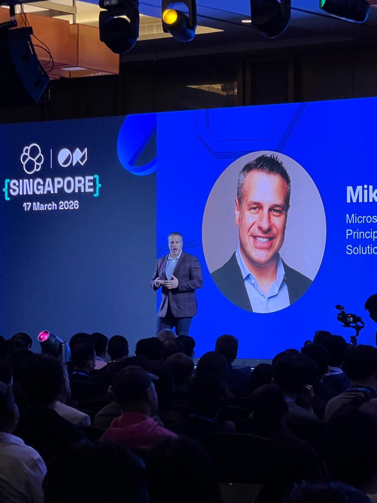 Mike Richter presenting on stage in Singapore with his official Microsoft headshot projected beside him.